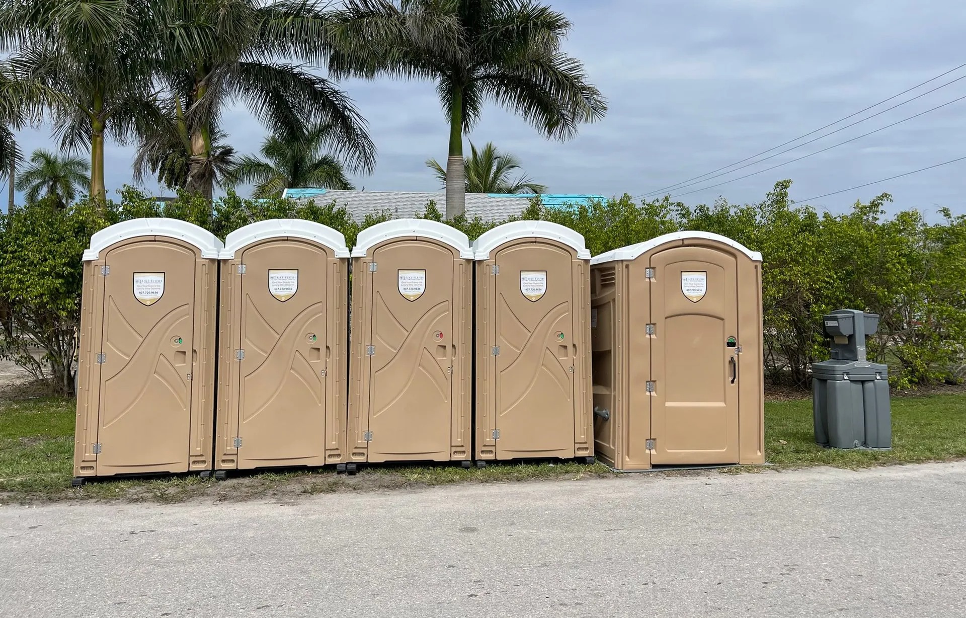 Luxe Flush porta potties and hand wash station set up under palm trees for a private event